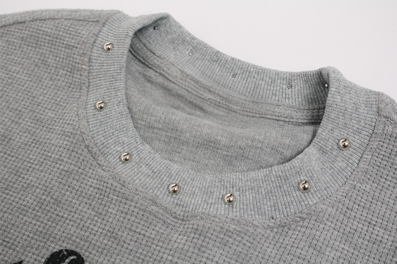 Gray ribbed graphic tee with metallic studded crew neckline and waffle-knit texture close-up