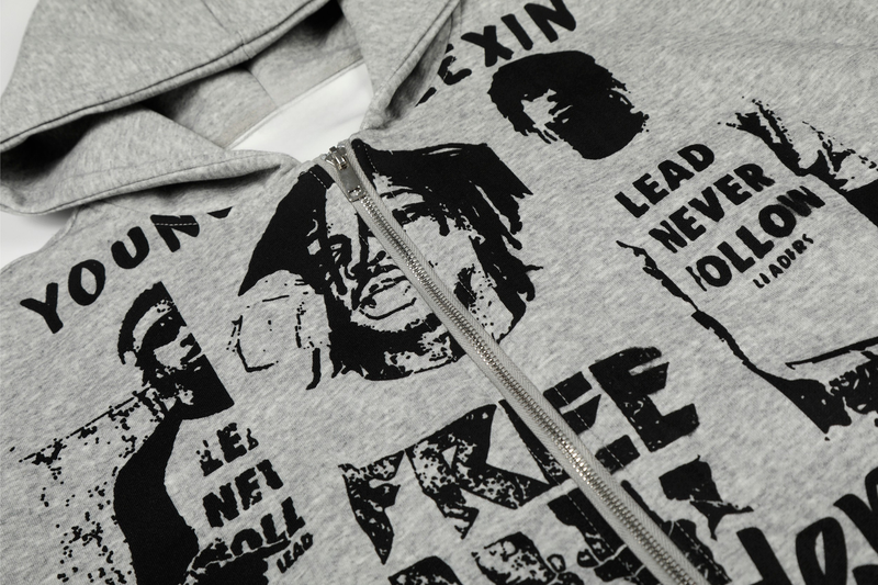 Close-up of light gray zip-up hoodie front showing graphic print and zipper