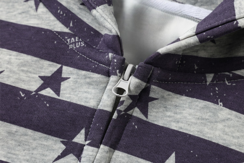 Close-up of the zipper pull and front seam on a purple and gray star print hoodie