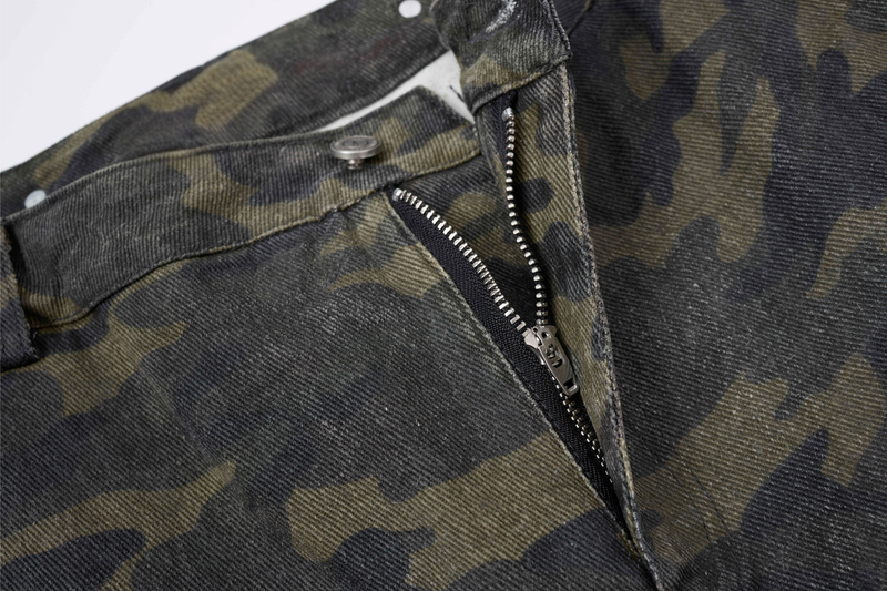 Close-up of camo cargo pants front waistband and zipper fly with silver hardware
