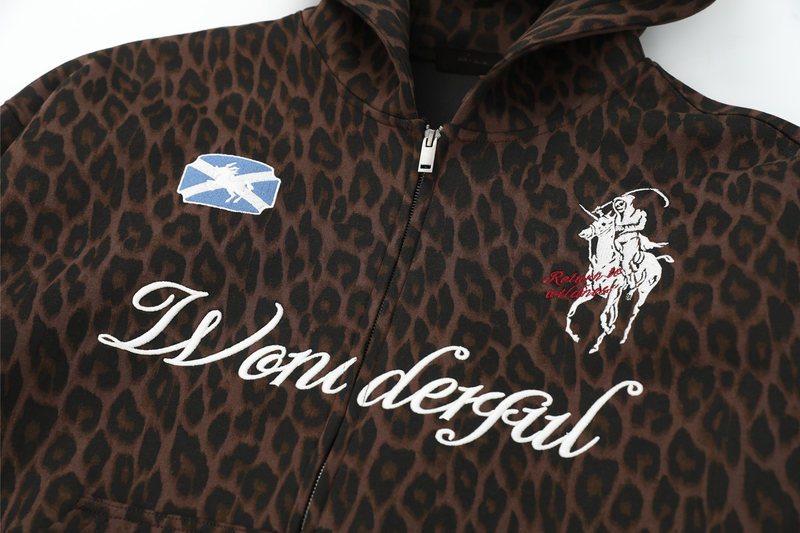 Front chest close-up of leopard print zip hoodie with "Wonderful" script and horse rider patch