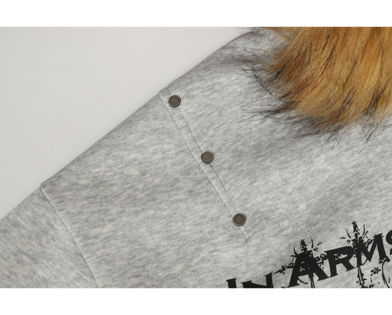 Close-up of light gray hoodie shoulder with tan faux fur hood trim and snap button detail