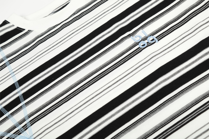 Close-up of black and white striped chest area with small light blue embroidered logo