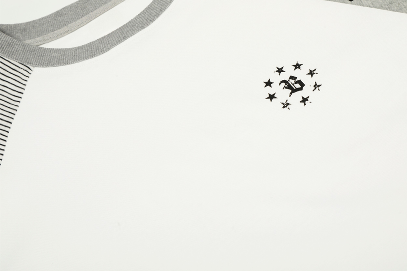 Close-up of front chest graphic on white tee near gray ribbed collar