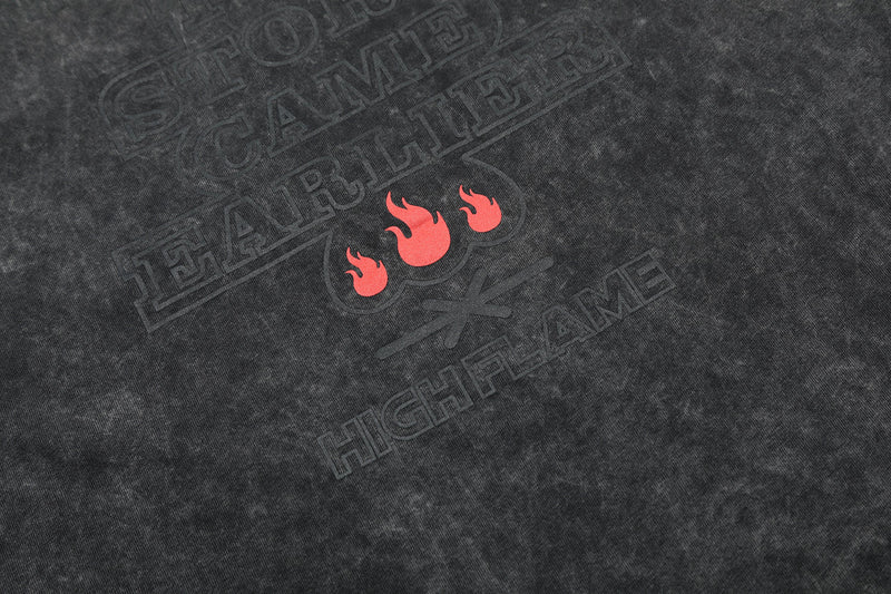 Washed black oversized cotton T-shirt with faded STOP CAME HERE graphic and red flame design on chest