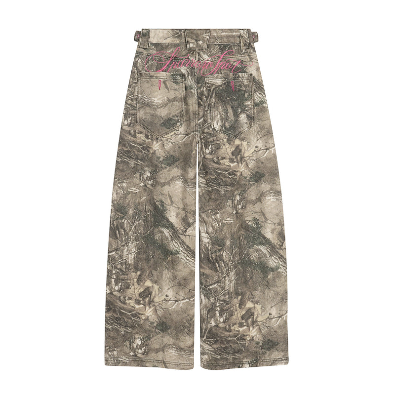 Back view of forest camo baggy pants with pink script embroidery and rear pockets