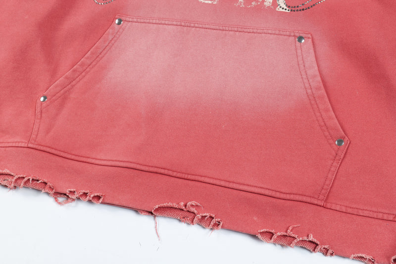 Close-up of red hoodie kangaroo pocket with metal rivets and distressed hem