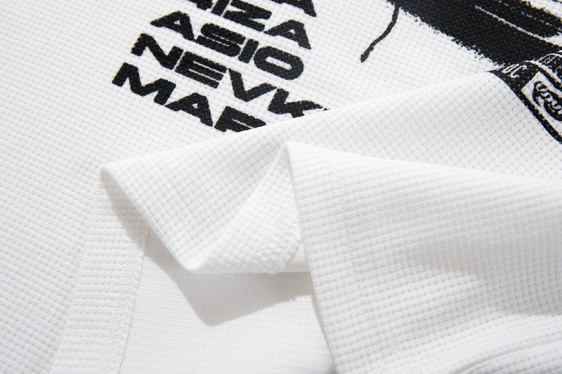 White graphic tee with bold black street-style print and textured waffle fabric close-up