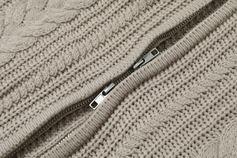 Close-up of the zipper and cable knit texture on a beige zip-up sweater