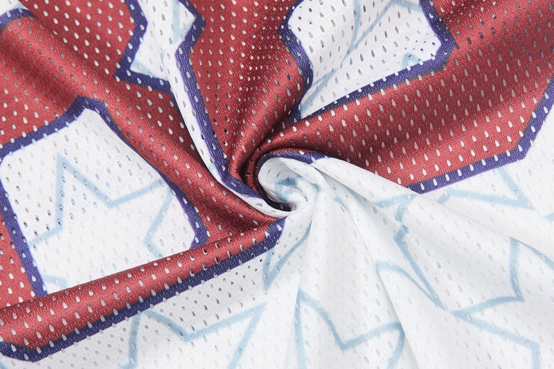 Close-up of red, white, and blue mesh football jersey fabric with star pattern and perforated texture