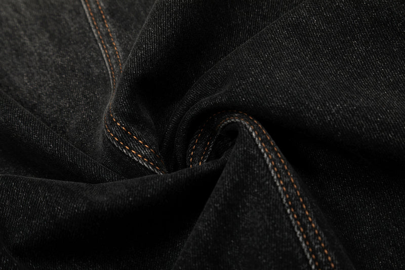 Close-up of black denim fabric with folded seam detail