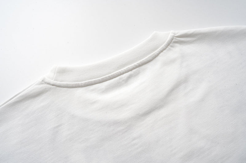 Close-up of off-white fabric and ribbed crew neck seam
