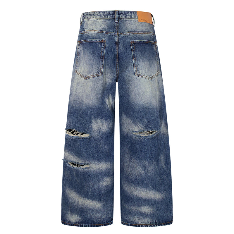 Back view of faded blue wide-leg jeans with distressing and patch label