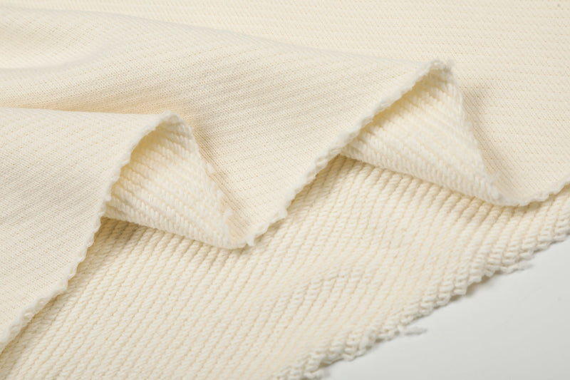 Close-up of cream sweatshirt fabric layers showing soft textured knit and raw edge