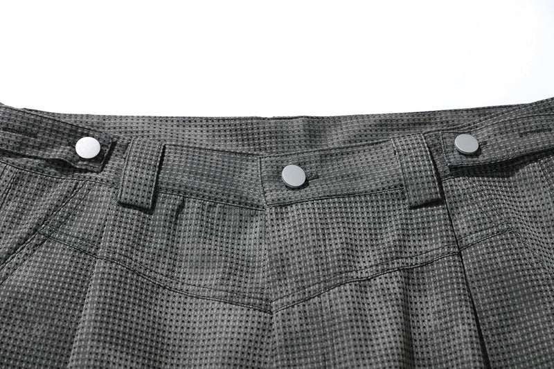 Close-up of black mesh shorts waistband and front fly with three snap buttons