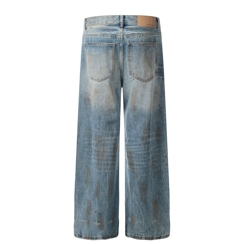 Back view of wide-leg jeans with faded rust-wash denim, patch label, and back pockets