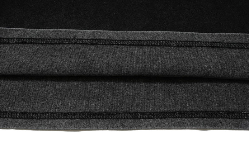 Close-up of vintage washed black graphic tee hem with visible stitching and textured fabric detailing