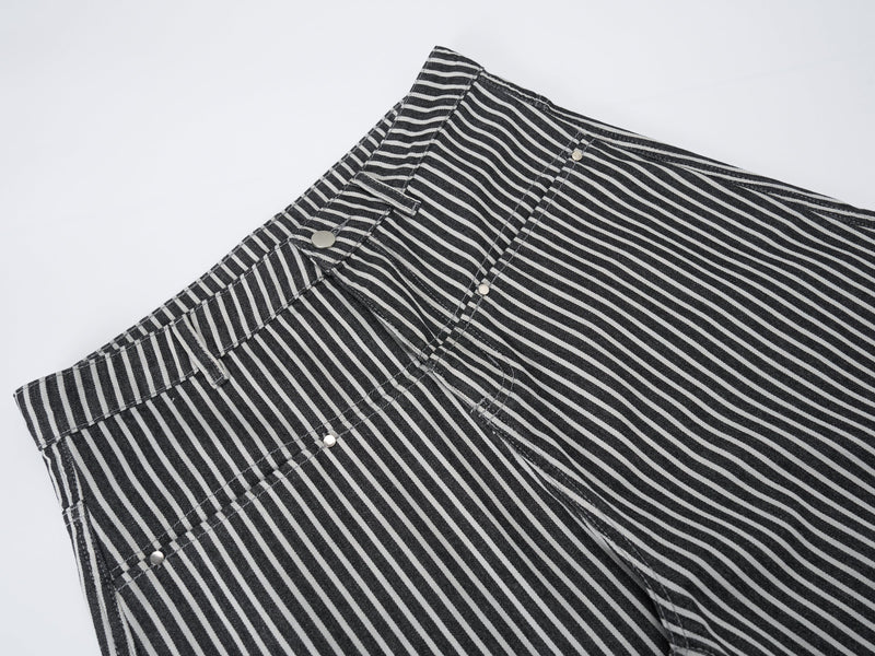 Close-up of striped jeans waistband, front pockets, belt loops, and snap details
