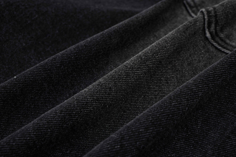 Extreme close-up of black denim fabric texture with diagonal weave pattern