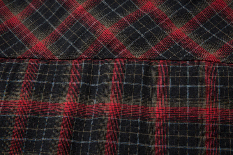 Close-up of the plaid flannel fabric in red, black, and tan tones