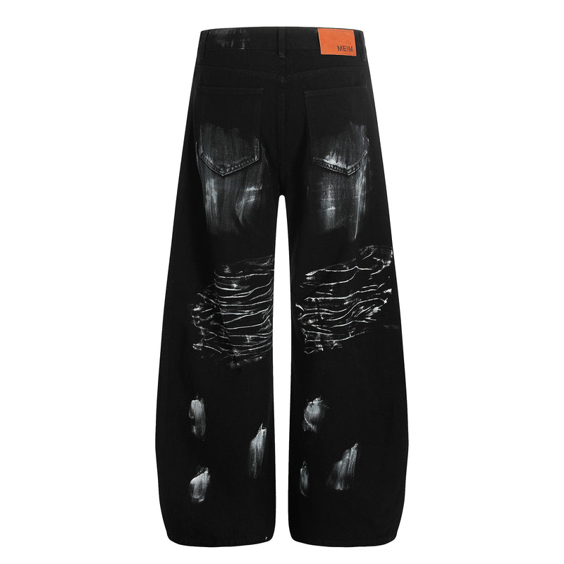 Back view of black wide-leg jeans with white brush-stroke print and orange MEIM label