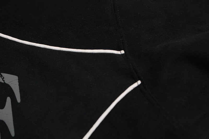 Close-up of black hoodie chest with white piping and graphic print