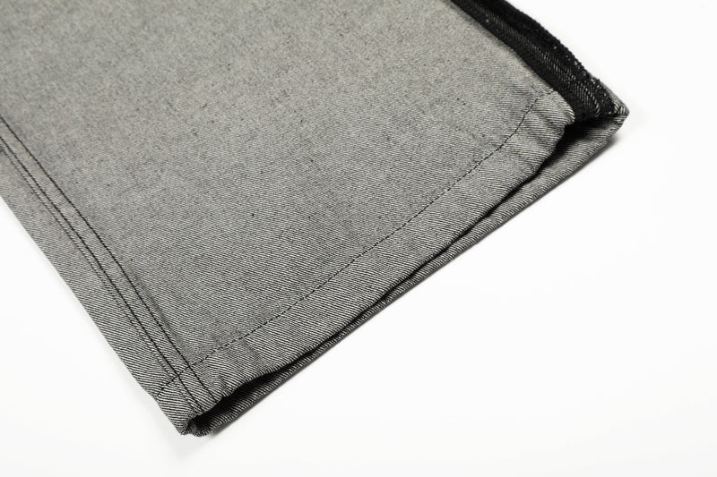 Close-up of wide-leg hem in gray denim with visible stitched seam