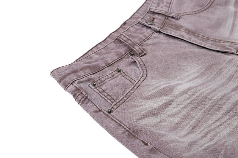 Close-up of brown denim front pocket and whiskered wash detail