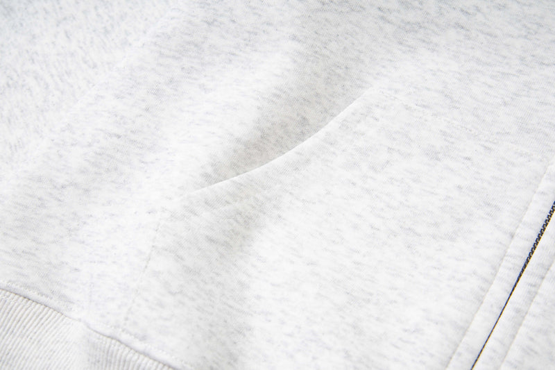 Close-up of white hoodie kangaroo pocket and side seam with heathered fabric texture