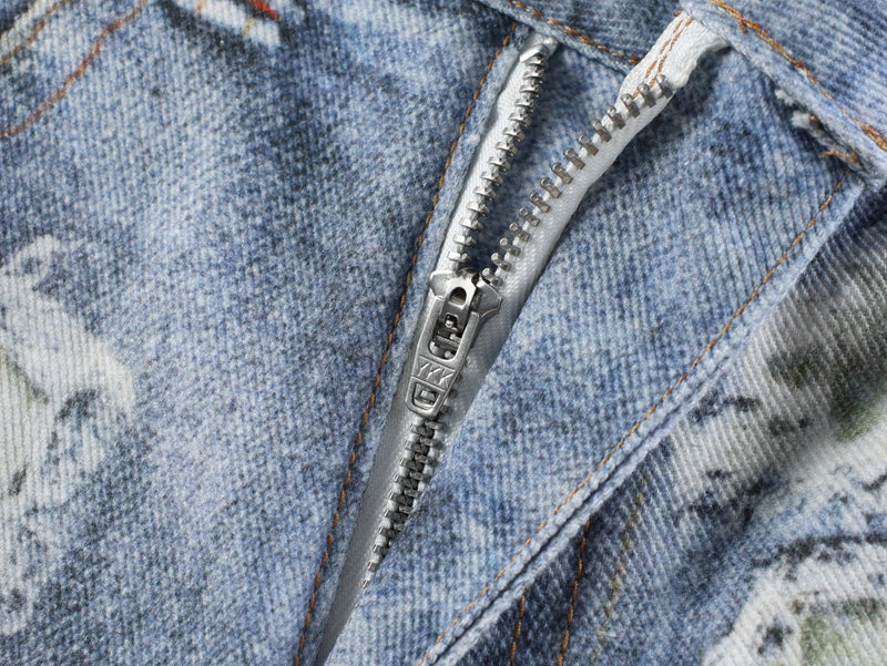 Close-up of metal zipper on blue floral patchwork denim