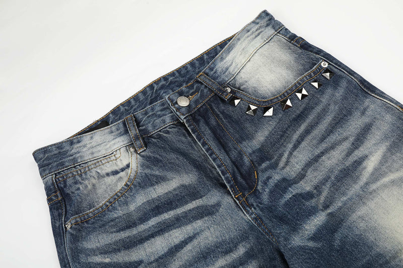 Top front section of faded blue jeans with studded pocket trim and button fly