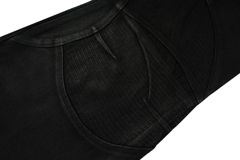 Close-up of black denim panel seam with curved stitching and textured fabric
