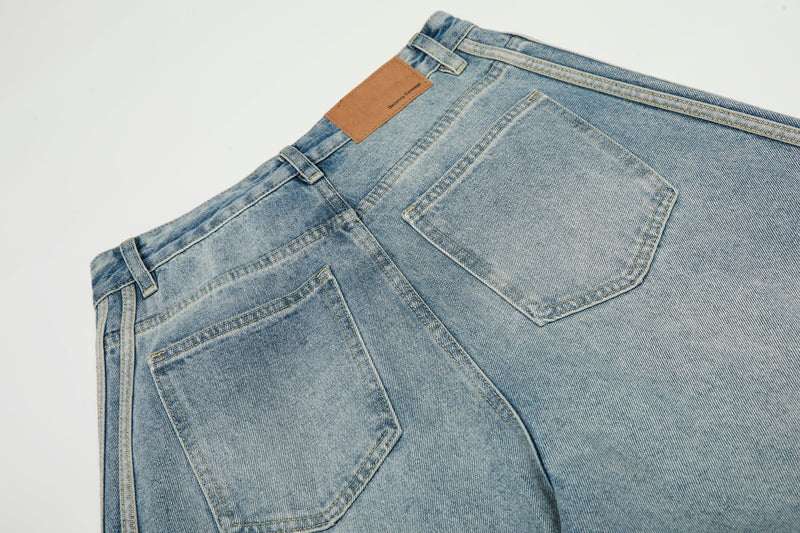 Close-up of back waistband and patch pocket on light wash barrel jeans