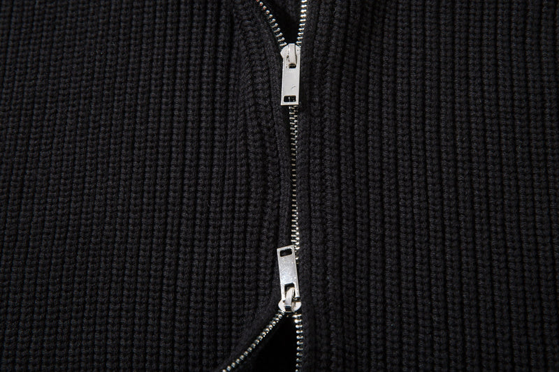 Close-up of black ribbed knit cardigan front zipper with silver hardware