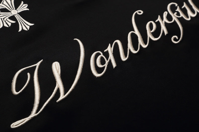 Black gothic polo shirt with white embroidered script and cross detail on textured cotton fabric