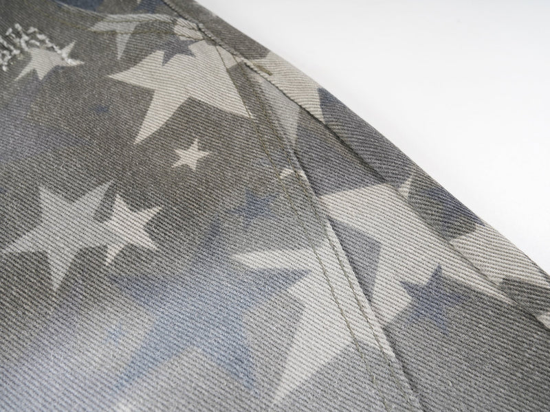 Close-up of star print fabric and seam on washed denim pants