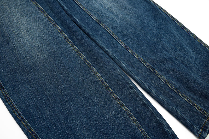 Close-up of blue wide-leg denim leg with center seam and faded wash