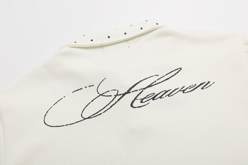 Cream polo shirt with studded collar and bold script graphic print on the chest, Y2K streetwear style