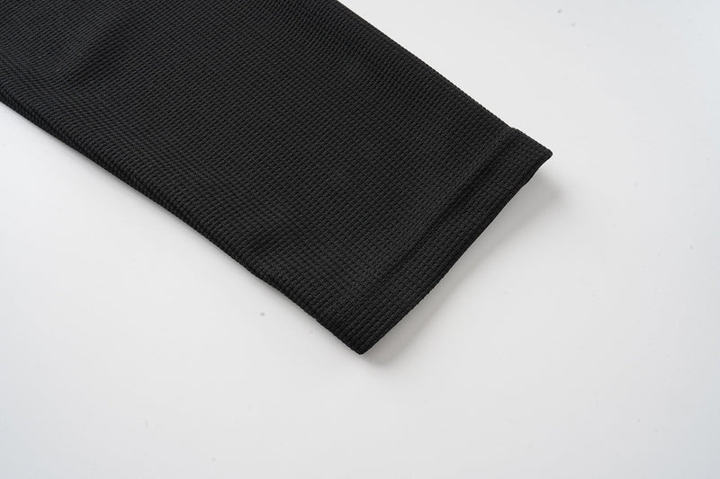 Close-up of black long sleeve cuff on waffle-knit tee