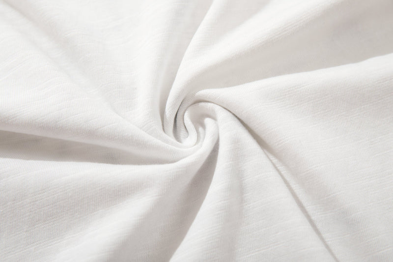 Soft white cotton fabric close-up with smooth knit texture, showing the streetwear tee material detail