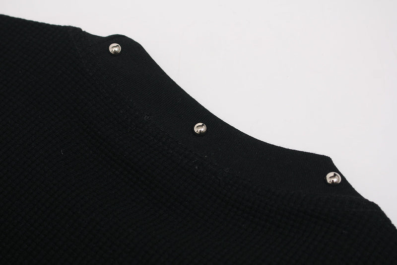 Black graphic T-shirt with a textured fabric edge and silver snap buttons on a clean white background