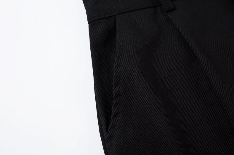 Close-up of side seam and curved panel detail on black wide-leg pants