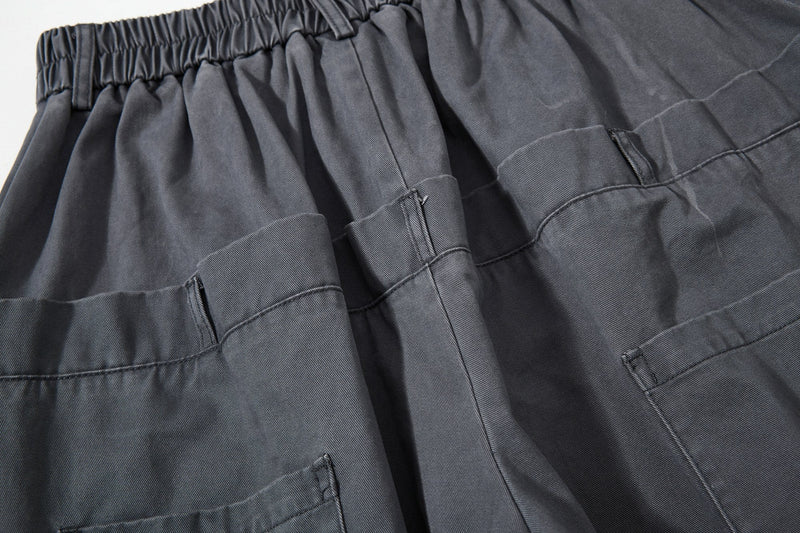 Close-up of dark gray cargo pockets and pleated front panel