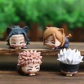 The Jujutsu Kaisen Chibi Figure Set, a 4-Piece PVC Collection, features four 4 cm chibi-style characters with expressive hairstyles and distinct features. These kawaii figures have exaggerated proportions and are displayed against a backdrop of blurred greenery.