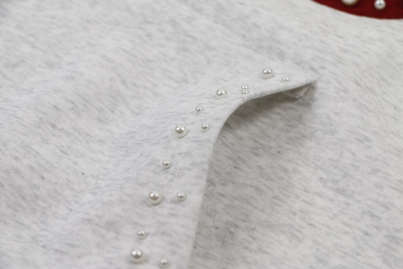 Close-up of gray hoodie pocket opening with pearl studs and soft fleece texture