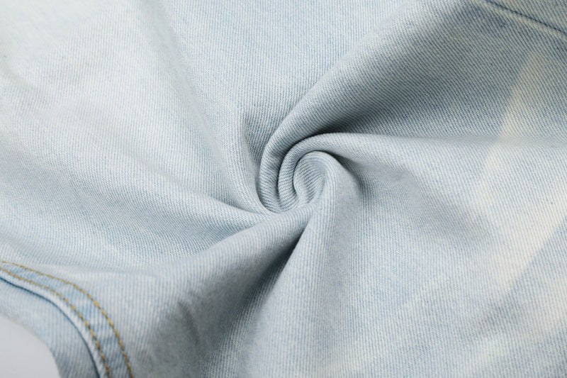 Close-up of light wash denim fabric texture with folded seam detail