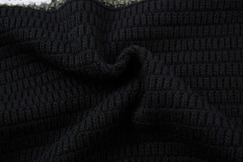 Close-up of black knit seam detail with striped pattern at the top