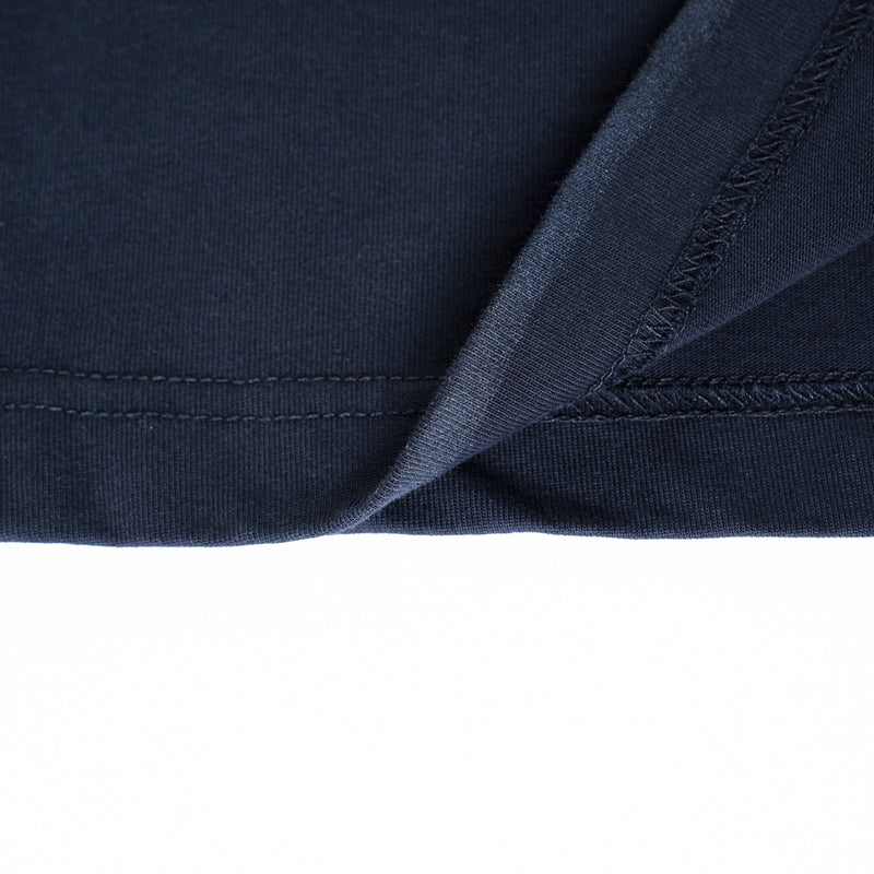 Close-up of navy vintage wash tee hem with visible double stitching and overlock seam detail