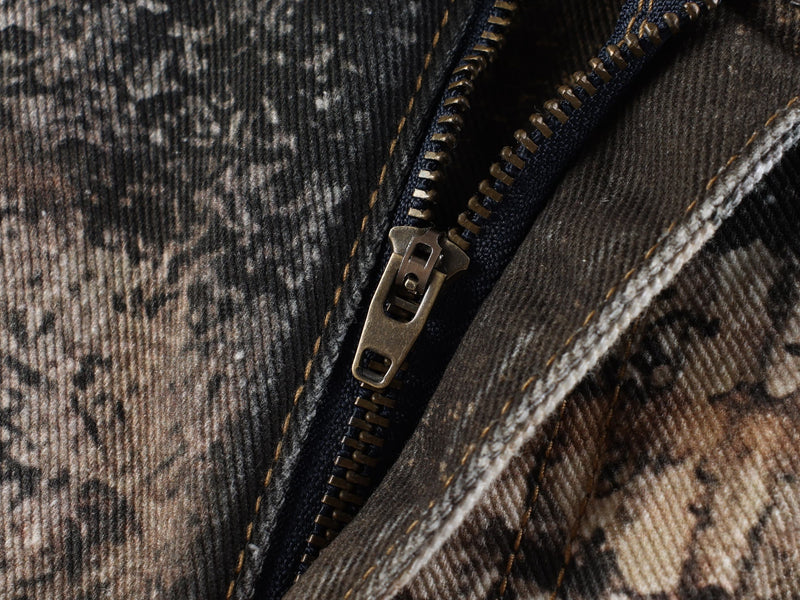 Close-up of the front zipper on brown animal print denim