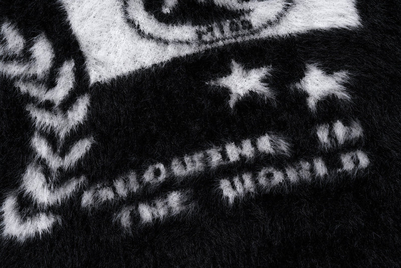 Close-up of white crest graphic details on the black fuzzy sweater